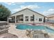 Backyard featuring a pool, rock waterfall feature, hot tub, and patio area at 2032 E Sierra Madre Ave, Gilbert, AZ 85296