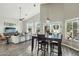 Open-concept dining area with a wooden table, adjacent to the living room with backyard views at 2032 E Sierra Madre Ave, Gilbert, AZ 85296