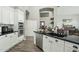 Kitchen with white cabinetry, stainless appliances, dark countertop, and view to other rooms at 2032 E Sierra Madre Ave, Gilbert, AZ 85296