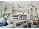 Open-concept living room with high ceilings, a ceiling fan, modern furniture, and seamless kitchen access at 2032 E Sierra Madre Ave, Gilbert, AZ 85296