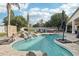 Beautiful backyard pool with a rock feature, waterfall, and surrounding green lawn at 2032 E Sierra Madre Ave, Gilbert, AZ 85296