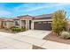 Charming home with stone accents, desert landscaping, a two-car garage, and a covered front porch at 20365 W Brittlewood Ave, Buckeye, AZ 85396