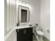 Stylish half-bath with a black vanity, gold fixtures, and playful checkered accents at 2066 N Canelo Hls, Mesa, AZ 85207