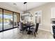 Elegant dining area with a modern chandelier, seating for four, and a view of the outdoor pool at 2066 N Canelo Hls, Mesa, AZ 85207