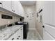 Organized laundry room with white cabinetry, granite counters, and modern washer and dryer at 2066 N Canelo Hls, Mesa, AZ 85207
