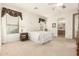 Bright bedroom featuring neutral carpet, a ceiling fan, and an ensuite bathroom at 24824 S Golfview Dr, Sun Lakes, AZ 85248