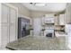 Functional kitchen with stainless steel appliances, light cabinets, and granite countertops at 26 S Tiago Dr, Gilbert, AZ 85233