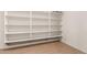 White storage shelves in a well-lit room with wood-look floors for added storage at 26693 N 82Nd Dr, Peoria, AZ 85383