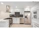 Well-lit kitchen with stainless steel appliances, white cabinets, and tile flooring at 2944 W Royal Palm Rd, Phoenix, AZ 85051