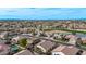 Expansive aerial view of homes, a golf course, and a pond in a well-planned community under a bright blue sky at 3401 E Isaiah Ave, Gilbert, AZ 85298