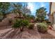 Landscaped backyard with beautiful plants, trees, rock ground cover, and outdoor seating area at 3401 E Isaiah Ave, Gilbert, AZ 85298