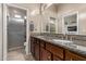 Bright bathroom features double sinks, granite counters, decorative backsplash, and tiled walk-in shower at 3401 E Isaiah Ave, Gilbert, AZ 85298