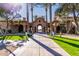 Inviting entrance to a community building with manicured lawns, palm trees, and an open archway leading inside at 3401 E Isaiah Ave, Gilbert, AZ 85298