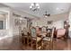 Open concept dining area with elegant chandelier, large table set, hardwood floors, and seamless transition to living area at 3401 E Isaiah Ave, Gilbert, AZ 85298