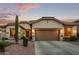 Charming home showcasing desert landscaping and a neutral-toned exterior with a spacious two-car garage at 3401 E Isaiah Ave, Gilbert, AZ 85298