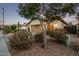 Inviting home exterior with desert landscaping, a well-maintained yard, and a welcoming front entrance at dusk at 3401 E Isaiah Ave, Gilbert, AZ 85298