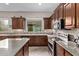 Spacious kitchen area featuring granite countertops, stainless steel appliances, and dark wood cabinetry at 3401 E Isaiah Ave, Gilbert, AZ 85298