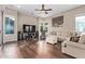 Comfortable living room showcasing wood floors, ample seating, and a large screen television at 3401 E Isaiah Ave, Gilbert, AZ 85298