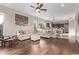 Open-concept living room with wood floors, flows into the kitchen area with an island at 3401 E Isaiah Ave, Gilbert, AZ 85298
