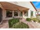 Covered patio with outdoor seating, ceiling fan, and manicured landscaping at 3401 E Isaiah Ave, Gilbert, AZ 85298