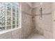 Walk in shower with glass block window, tile surround and bench seating at 3401 E Isaiah Ave, Gilbert, AZ 85298