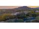 Aerial view of a sprawling estate featuring unique architecture, lush desert landscaping, and mountain views at 34460 N 79Th Way, Scottsdale, AZ 85266