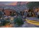 Luxurious courtyard featuring a water feature, stone architecture, outdoor dining, and desert landscaping at 34460 N 79Th Way, Scottsdale, AZ 85266