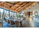Elegant dining room featuring exposed-beam vaulted ceilings, stone floors, and expansive windows with scenic views at 34460 N 79Th Way, Scottsdale, AZ 85266