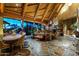 Elegant dining room featuring exposed-beam vaulted ceilings, stone floors, and views of the Arizona landscape at 34460 N 79Th Way, Scottsdale, AZ 85266