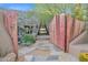 Unique front entry features a stone wall and a custom metal gate, alongside desert landscaping at 34460 N 79Th Way, Scottsdale, AZ 85266