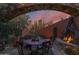 Stone patio with outdoor dining table and metal fireplace feature under an arched stone frame at 34460 N 79Th Way, Scottsdale, AZ 85266
