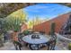 Desert landscaping surrounds a stone patio with dining table viewed through an archway at 34460 N 79Th Way, Scottsdale, AZ 85266