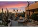 Outdoor lounge area with comfortable seating, a fire pit, and serene desert views at sunset at 34460 N 79Th Way, Scottsdale, AZ 85266