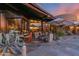 Expansive outdoor patio with stone flooring, multiple seating areas, umbrellas, and a built-in bar for entertaining at 34460 N 79Th Way, Scottsdale, AZ 85266