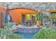 Outdoor patio features a stone arch, dining set, desert landscaping, fire feature, and small water feature at 34460 N 79Th Way, Scottsdale, AZ 85266
