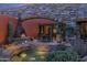 Outdoor patio features a stone arch, dining set, desert landscaping, fire feature, and small water feature at 34460 N 79Th Way, Scottsdale, AZ 85266
