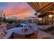 Tranquil pool area with a covered dining space, desert landscaping, and stunning sunset views at 34460 N 79Th Way, Scottsdale, AZ 85266