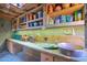 Well-organized potting bench featuring ample storage, rustic wood countertop and stone tile floor at 34460 N 79Th Way, Scottsdale, AZ 85266