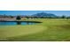 Scenic view of golf course and pond with mountain backdrop at 3706 E Ravenswood Dr, Gilbert, AZ 85298
