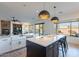 Gourmet kitchen with white cabinets, dark island, modern lighting and open floorplan to living room at 3706 E Ravenswood Dr, Gilbert, AZ 85298