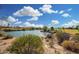Scenic pond view featuring blue skies, a small waterfall, and surrounding lush vegetation at 3706 E Ravenswood Dr, Gilbert, AZ 85298