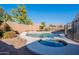 Backyard swimming pool with an attached spa, waterfall feature, and a surrounding safety fence at 3706 E Ravenswood Dr, Gilbert, AZ 85298