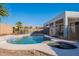 Backyard oasis with pool, spa, and rock waterfall surrounded by desert landscaping and wrought iron fence at 3706 E Ravenswood Dr, Gilbert, AZ 85298