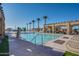 Community swimming pool with lounge chairs, covered patio and palm trees at 3706 E Ravenswood Dr, Gilbert, AZ 85298