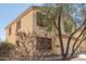 Angled view of a tan two-story house showcasing its stucco siding, shutters, and desert landscaping at 37379 W Amalfi Ave, Maricopa, AZ 85138