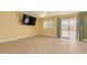 Bright living room with wood floors, ceiling fan, sliding glass doors and a mounted television at 37379 W Amalfi Ave, Maricopa, AZ 85138