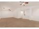 Spacious living room with carpet flooring, ceiling fans, and lots of natural light at 37379 W Amalfi Ave, Maricopa, AZ 85138