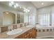 Dual sinks with beautiful tile countertops and a relaxing tub with unique glass block windows at 38820 N 10Th St, Phoenix, AZ 85086