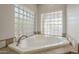 A beautiful bathroom featuring a large bathtub with stylish tiling and glass block windows at 38820 N 10Th St, Phoenix, AZ 85086