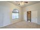 This bedroom has light colored walls, carpet, a window with an arch and closet with sliding doors at 38820 N 10Th St, Phoenix, AZ 85086